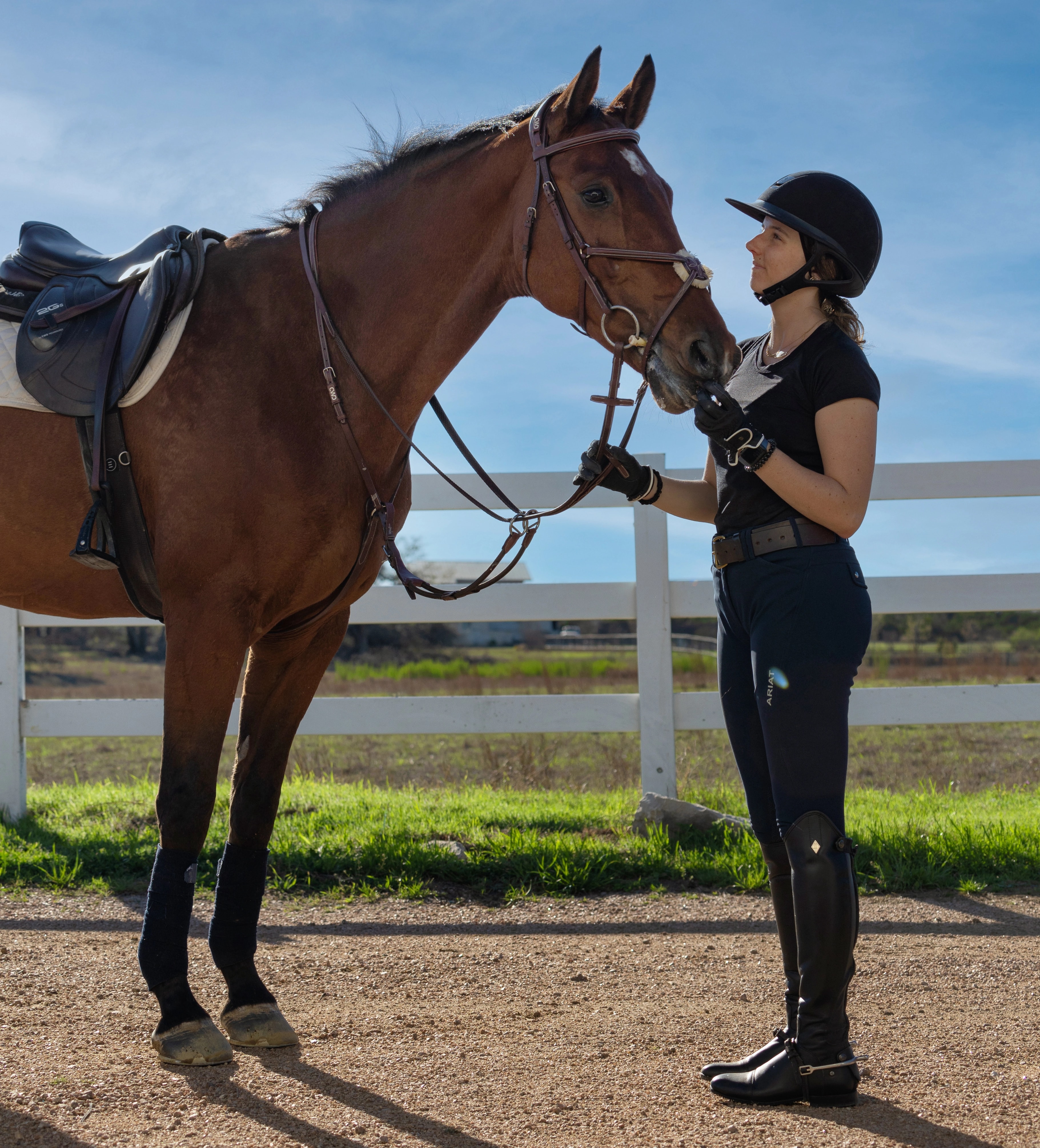 A rider standing beside a prepared horse at the Austin center